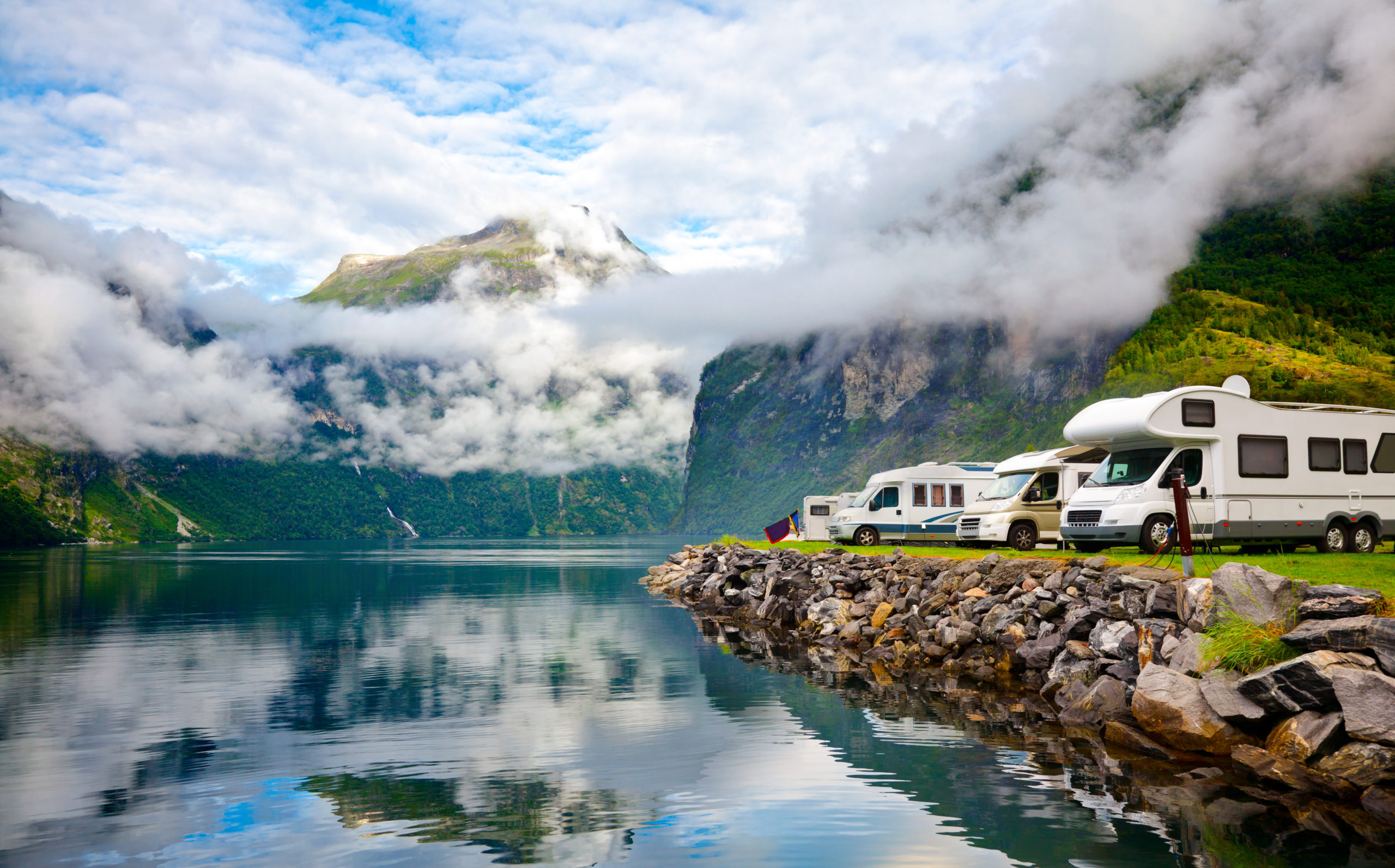 Campervan RV vehicles at norwegian camping by a fjord